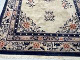 rug with oriental design on a white ground with a blue border