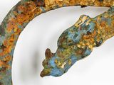 a close up of a rusted metal object with a lizard on it