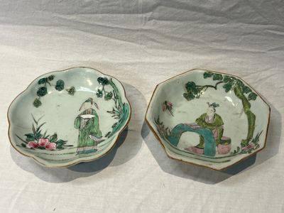 two bowls with asian designs on them on a table