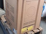 a cardboard box on a pallet with a washing machine in it