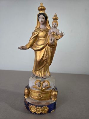 statue d'une femme tenant un enfant dans ses bras, posée sur un socle en marbre