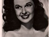 an old black and white photo of a woman with a smile on her face