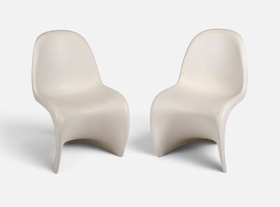 deux chaises blanches placées l'une à côté de l'autre sur une surface blanche
