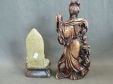 a statue of a woman holding a knife next to a stone