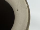 a close up of a vase on a white surface