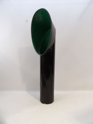 un vase noir et vert posé sur une table blanche
