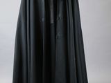 a black cloak is hanging on a wooden hanger