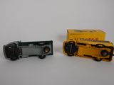 two toy trains sitting next to each other on a white surface