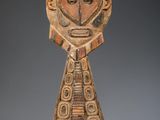 l'image d'une sculpture en bois représentant un visage sur un support