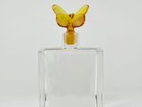 an image of a glass bottle with a yellow butterfly on top