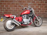 a red motorcycle that is parked in front of a brick wall
