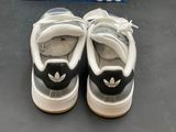 pair of white and black adidas sneakers sitting on top of a table