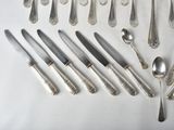 a lot of silverware on a table with spoons and knives