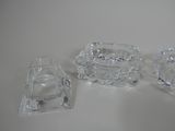 three pieces of glass sitting on a white surface