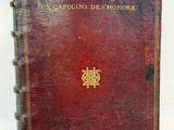 an old red book with a gold emblem on the cover
