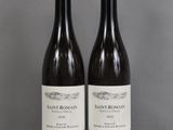 two bottles of wine sitting on top of a table next to each other