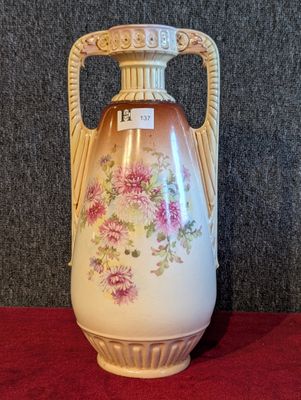 un vase muni d'une anse décorée de fleurs
