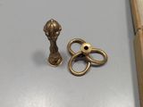 a pair of scissors and a gold object on a table
