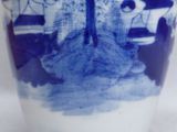a blue and white vase with a picture of a tree on it