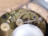 a close up of a clock with a white ball inside of it
