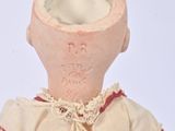 a small doll that is sitting on a white surface