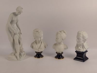 trois statues représentant un homme et une femme sur fond blanc