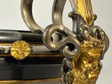 a black and gold vase with a lion head on it