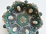 bol en céramique bleu et vert orné de visages et de fleurs