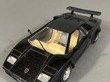 maquette de voiture Lamborghini noire posée sur une surface blanche