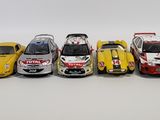 five small cars lined up in a row on a white surface