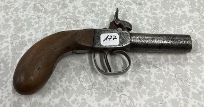 un vieux pistolet muni d'une étiquette, posé sur une table