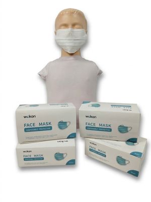 une personne portant un masque à côté de trois boîtes de masques