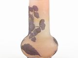 a vase with purple flowers on it sitting on a white surface