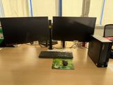 two computer monitors and a keyboard on a desk
