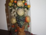 a vase with a bunch of fruit in it on a table