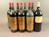 six bottles of wine are lined up in a row on a table