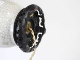 a black and white vase with a rope hanging from it