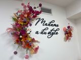 a wall with flowers and a sign that says madame au style