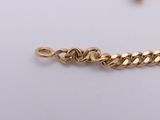 a close up of a gold chain on a white surface