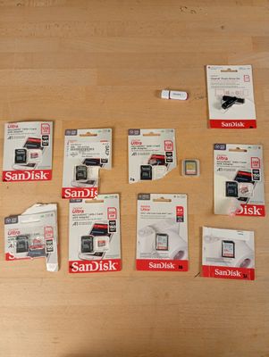 a lot of sandisk sd cards sitting on a table