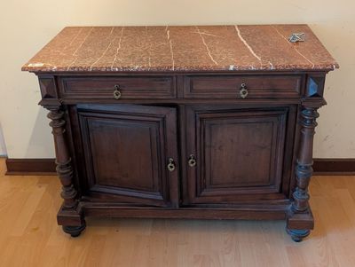 une armoire en bois avec un plateau en marbre, posée sur un parquet en bois massif