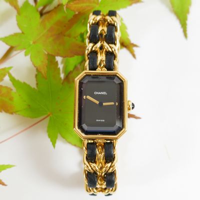an image of a black and gold watch sitting on top of a table