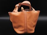 the small leather tote bag is made from soft tan leather
