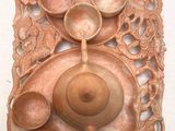 a wooden plate with a teapot and bowls on it