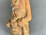 an ancient statue of a woman holding a child
