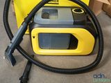 a yellow and black vacuum with a hose on the floor