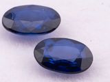 two blue sapphires on a white surface