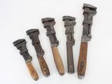 four old tools are lined up on a white surface