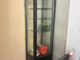 une vitrine en verre dans le coin d'une pièce