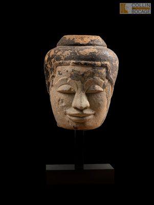 une tête humaine sculptée dans la pierre, sur fond noir